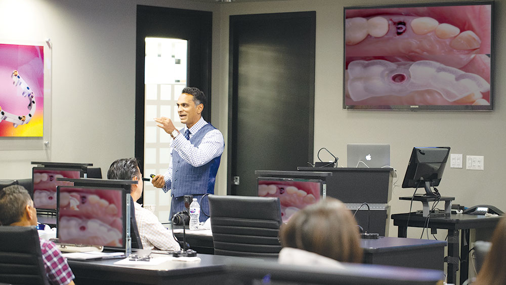 Dr. Paresh Patel speaking to a group of dentists at a live CE event